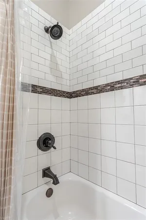 a bathroom with a sink a toilet a mirror and shower curtain