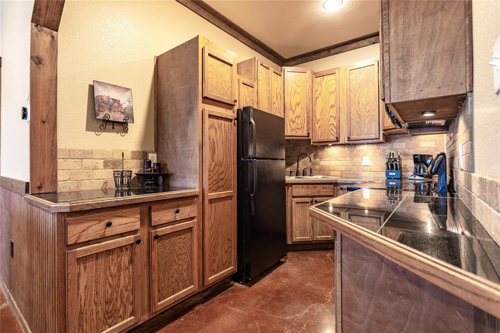 313 Wolf Creek Road Lorena, TX 76655 - Photo 35 of 39 a kitchen with granite countertop a refrigerator and a sink