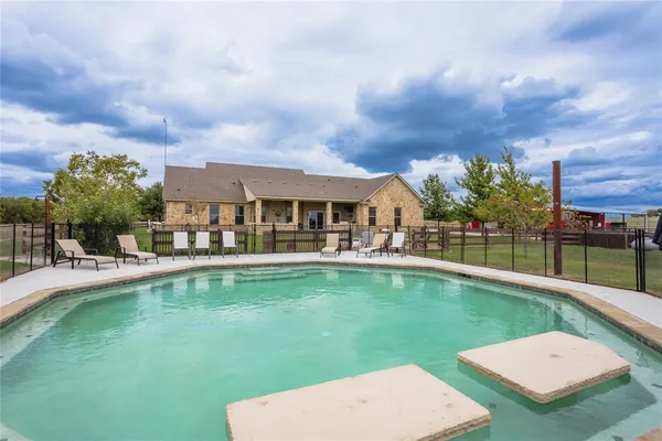 a view of a house with swimming pool and porch with furniture