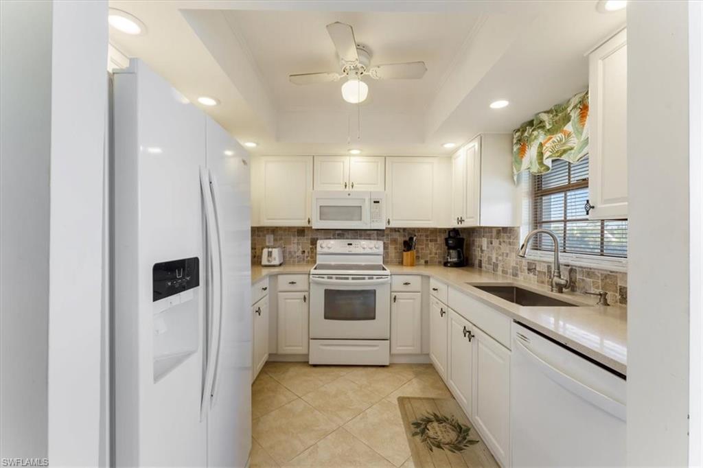 315 St Andrews Boulevard, Unit B32 Naples, FL 34113 - Photo 14 of 27 a kitchen with a sink stainless steel appliances and white cabinets