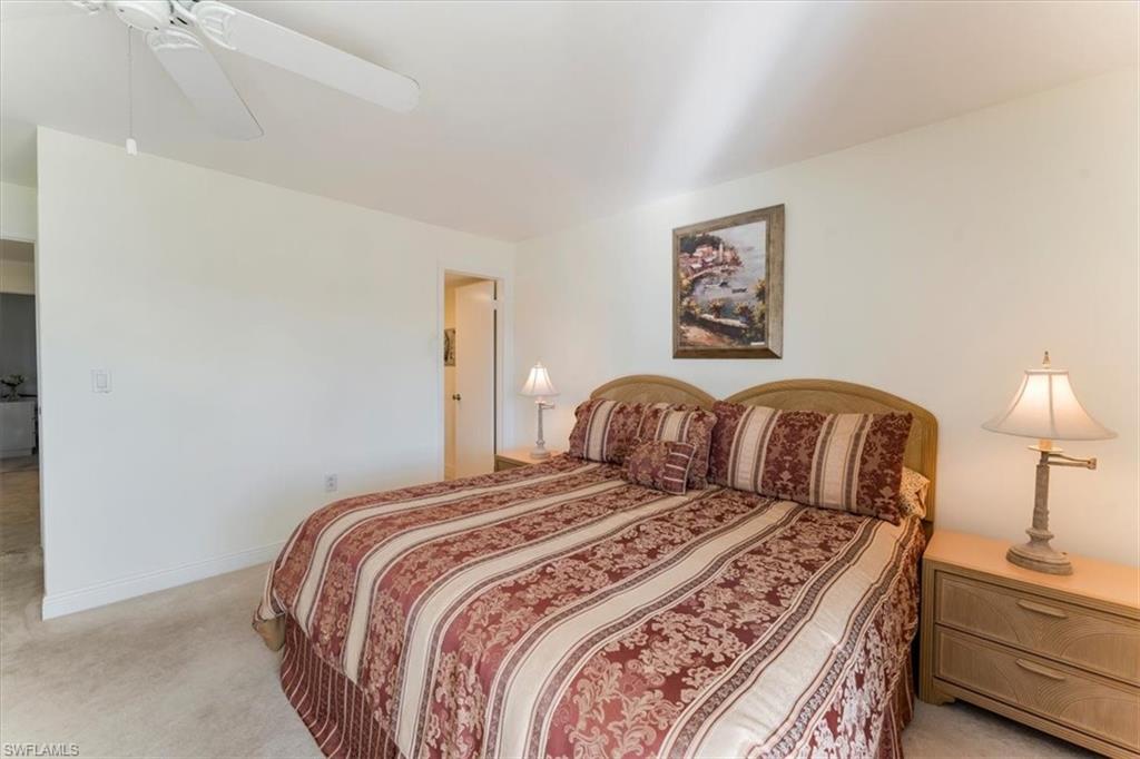 315 St Andrews Boulevard, Unit B32 Naples, FL 34113 - Photo 16 of 27 a bedroom with a bed and a lamp on dresser