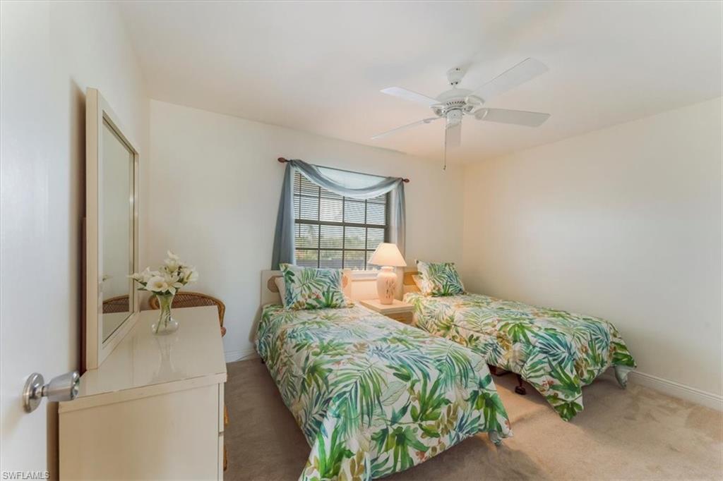 315 St Andrews Boulevard, Unit B32 Naples, FL 34113 - Photo 22 of 27 a bedroom with a bed and a chandelier