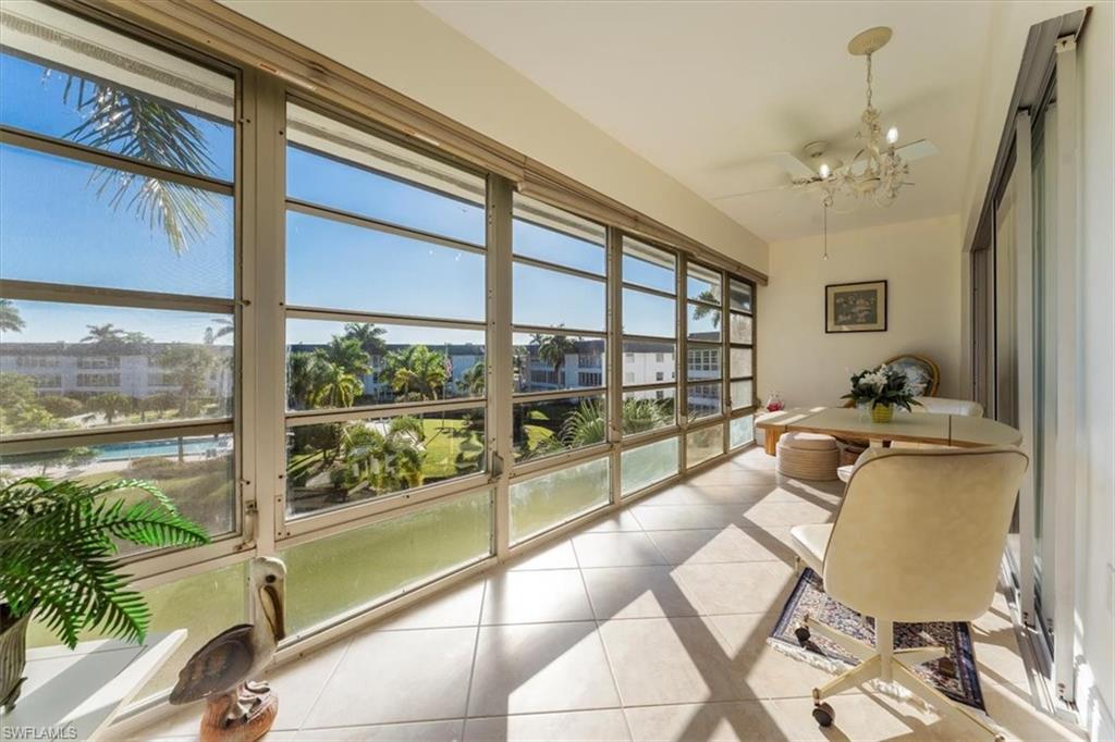 315 St Andrews Boulevard, Unit B32 Naples, FL 34113 - Photo 26 of 27 a living room with furniture and a floor to ceiling window