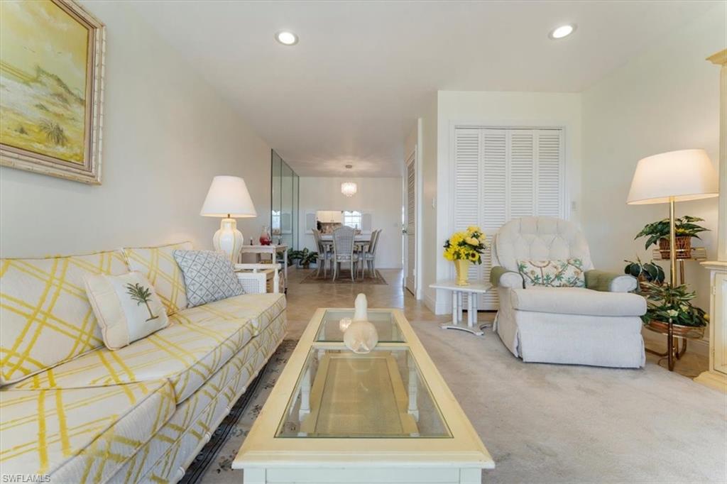 315 St Andrews Boulevard, Unit B32 Naples, FL 34113 - Photo 6 of 27 a living room with furniture and a lamp