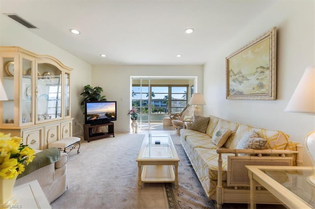 315 St Andrews Boulevard, Unit B32 Naples, FL 34113 - Photo 7 of 27 a living room with furniture a fireplace and a flat screen tv