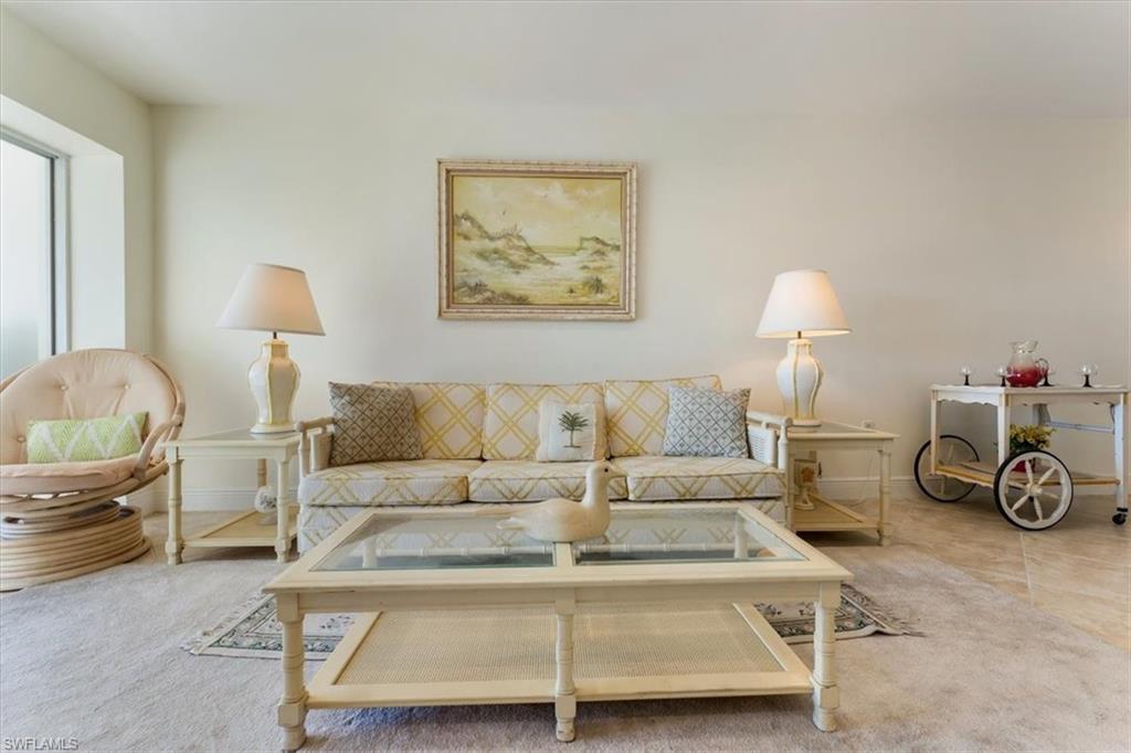 315 St Andrews Boulevard, Unit B32 Naples, FL 34113 - Photo 8 of 27 a living room with furniture and a lamp