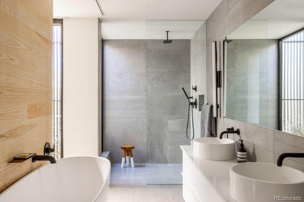 3837 High Street Denver, CO 80205 - Photo 17 of 46 a bathroom with a tub shower sink and mirror