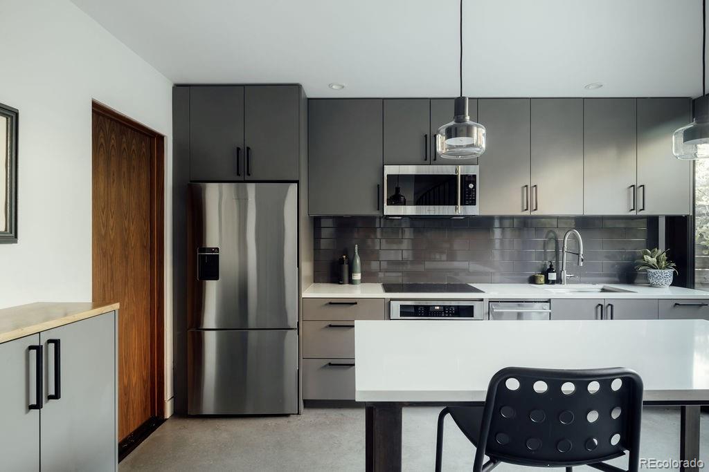 3837 High Street Denver, CO 80205 - Photo 30 of 46 a kitchen with stainless steel appliances granite countertop a refrigerator a stove a sink and white cabinets