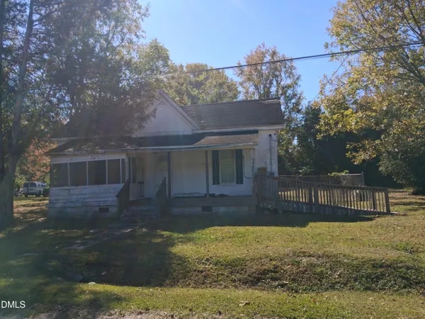 a view of a house with backyard and a tree