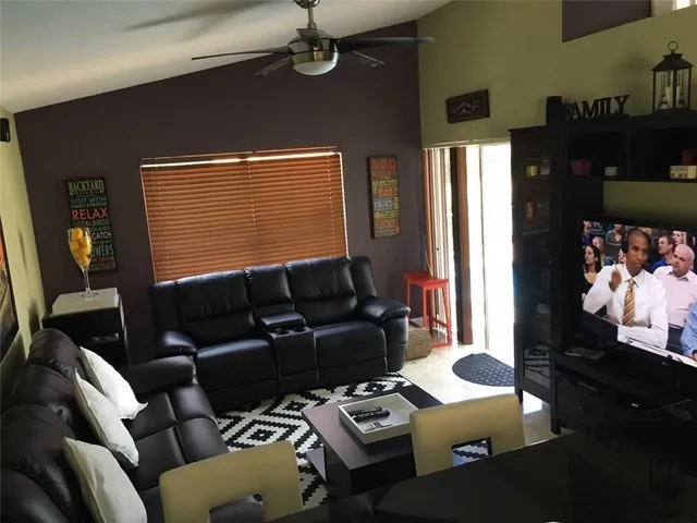 a living room with furniture a chandelier and a window