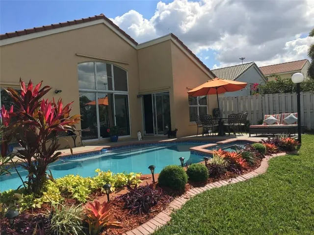 a front view of a house with swimming pool garden and patio