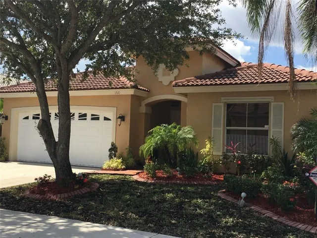 a view of a lake in front of a house with lots of green space
