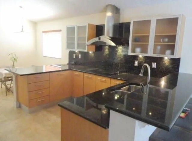a kitchen with granite countertop a sink and a stove