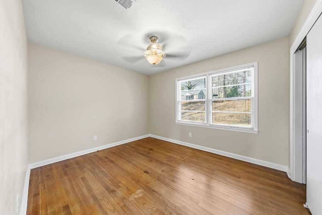 4320 Canady Street Columbus, GA 31909 - Photo 12 of 36 an empty room with wooden floor chandelier fan and windows