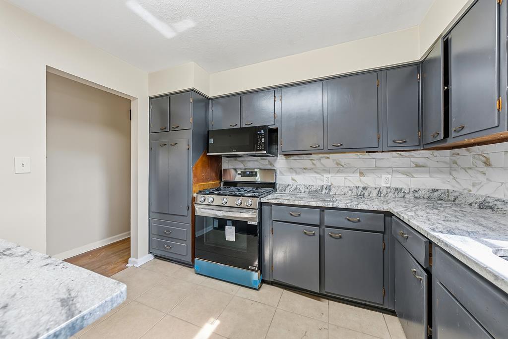 4320 Canady Street Columbus, GA 31909 - Photo 8 of 36 a kitchen with stainless steel appliances granite countertop a stove a sink and a refrigerator with cabinets