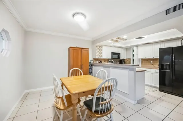 a kitchen with refrigerator cabinets dining table and chairs