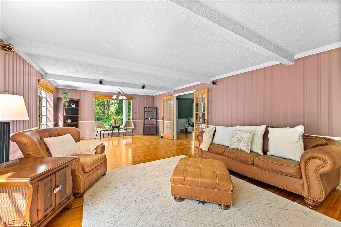 1375 North Revere Road Akron, OH 44333 - Photo 14 of 50 Hardwood flooring, painted paneled walls, and exposed ceiling beams