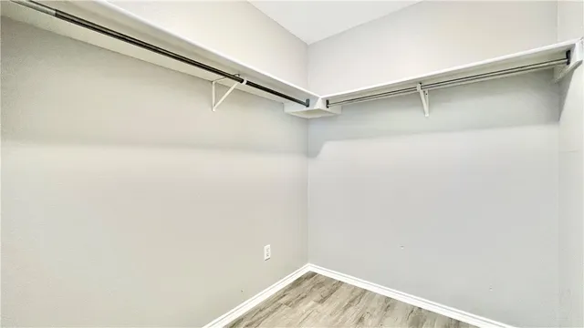 a view of walk in closet with empty racks