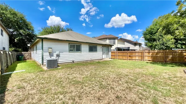 a backyard of a house with table and chairs