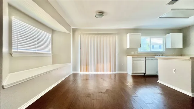 a view of a kitchen with wooden floor and a window
