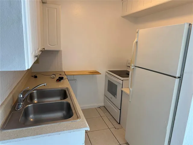 a kitchen with a refrigerator and a sink
