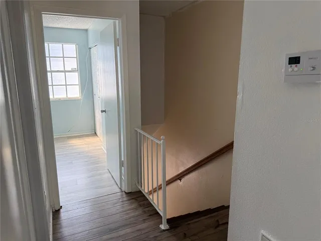 a view of a hallway with wooden floor and entryway