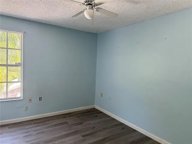 an empty room with a window and a fan