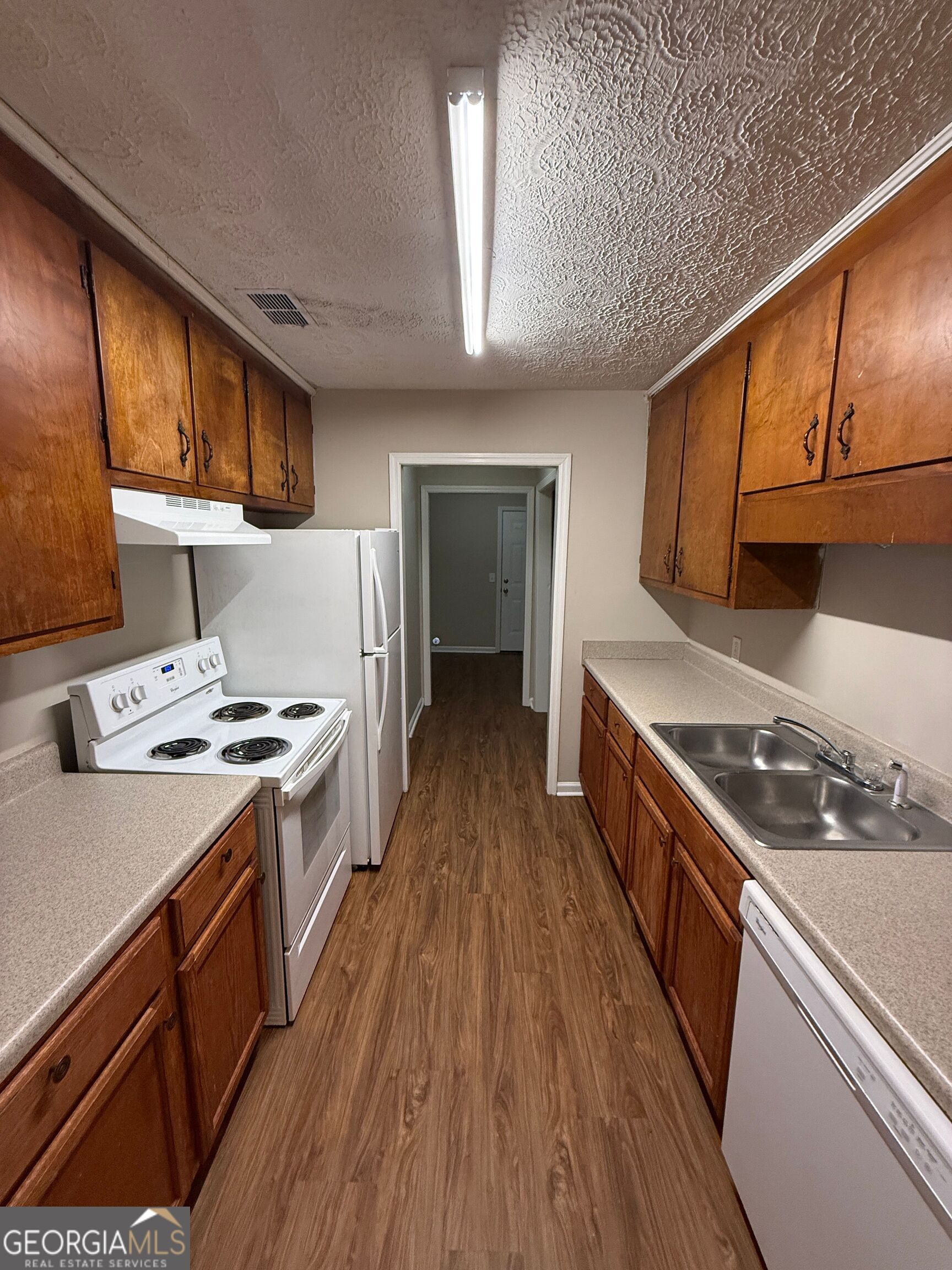 110 St Andrews Court, Unit 110 Athens, GA 30605 - Photo 3 of 13 a kitchen with wooden cabinets and a stove top oven
