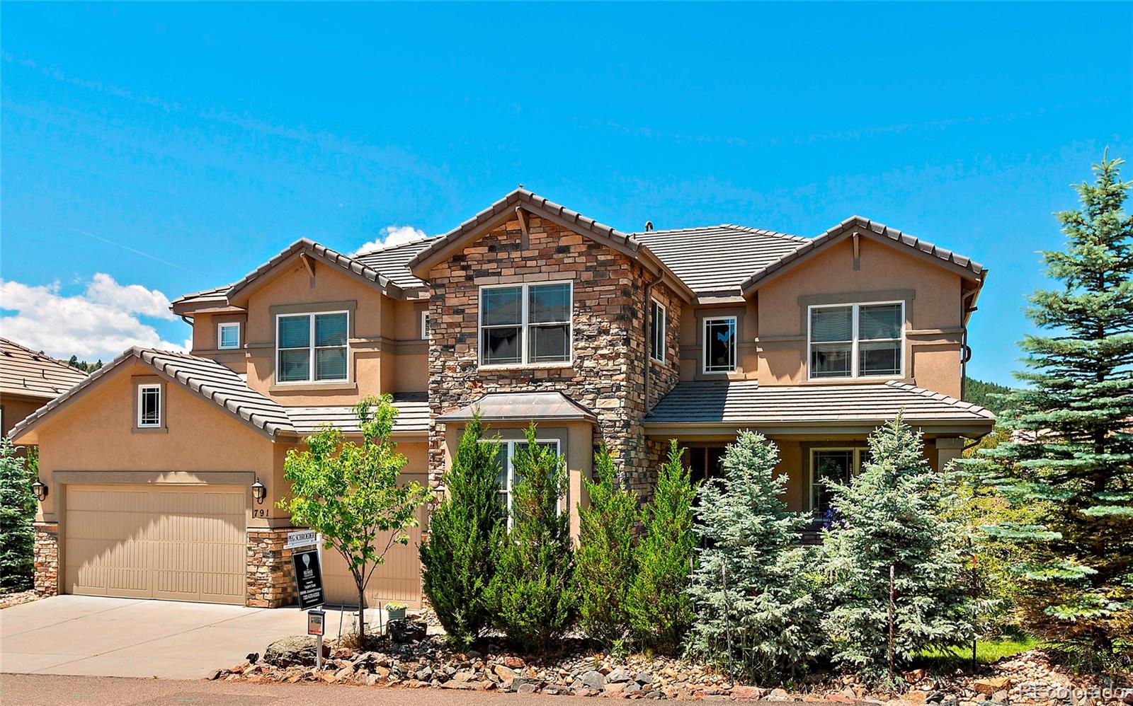 a front view of a house with a yard and potted plants