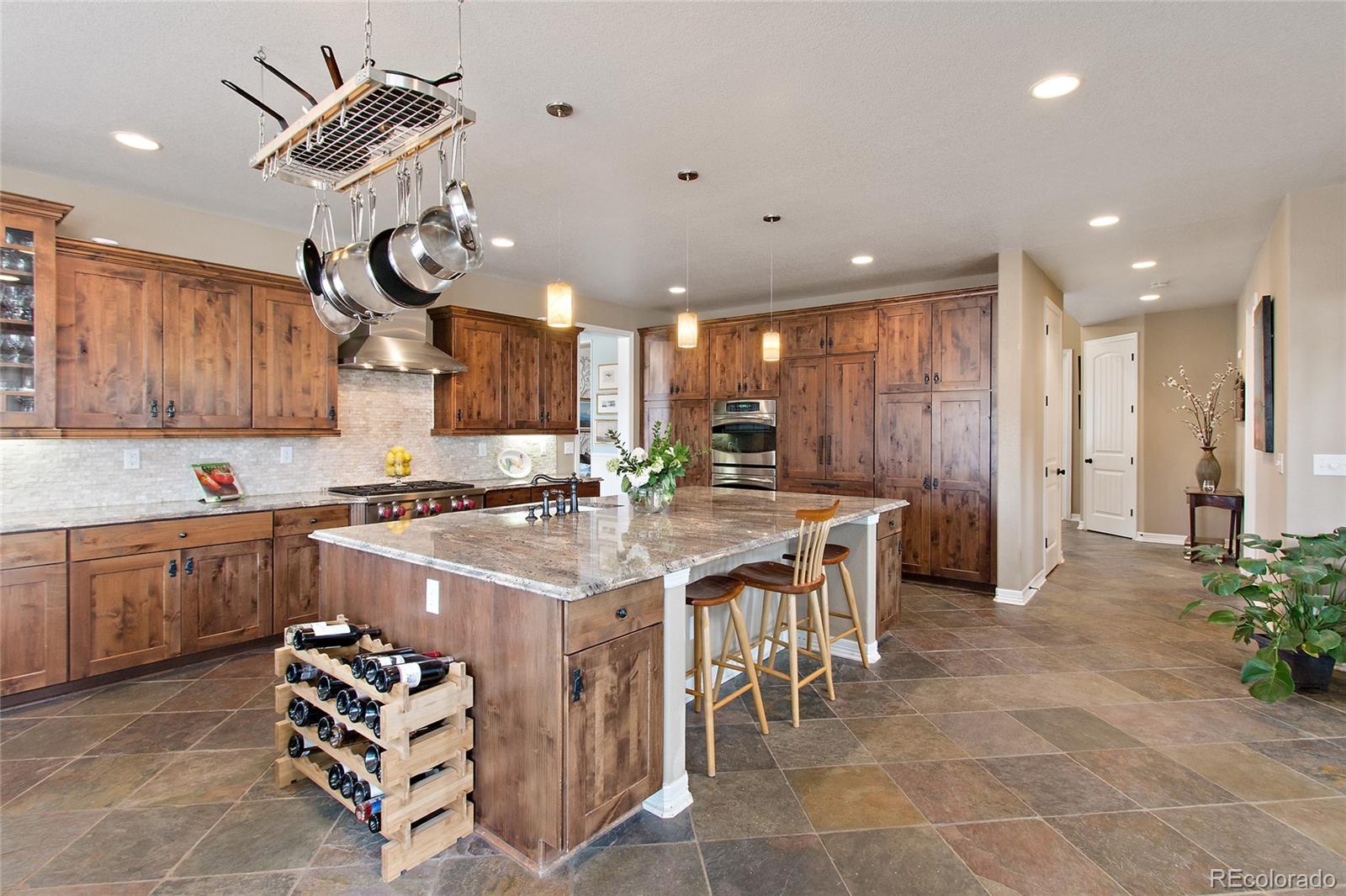791 Elk Rest Road Evergreen, CO 80439 - Photo 11 of 35 a kitchen with stainless steel appliances a sink a stove a refrigerator cabinets and dining table