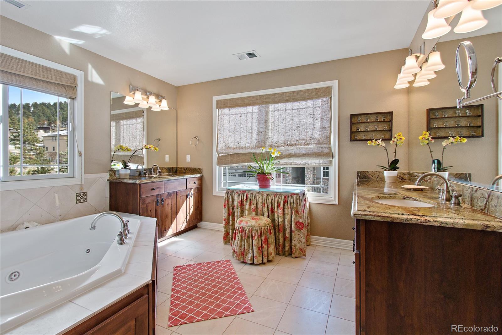 791 Elk Rest Road Evergreen, CO 80439 - Photo 21 of 35 a bathroom with a tub a sink a mirror and a shower