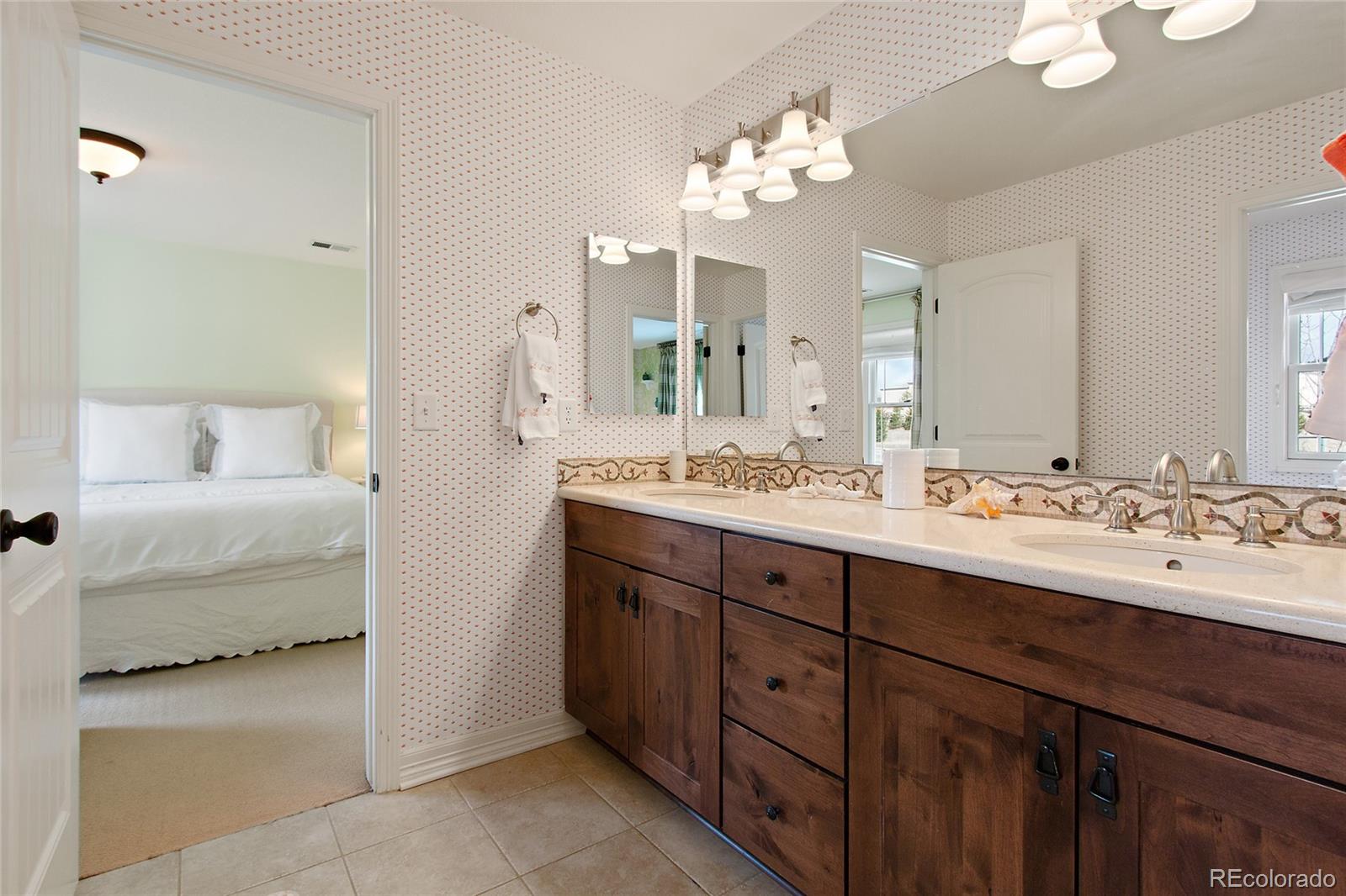 791 Elk Rest Road Evergreen, CO 80439 - Photo 25 of 35 a en suite bathroom with a double vanity sink double and mirror