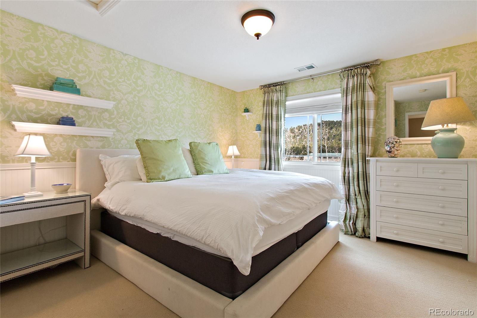 791 Elk Rest Road Evergreen, CO 80439 - Photo 26 of 35 a large bed sitting in a room next to a lamp