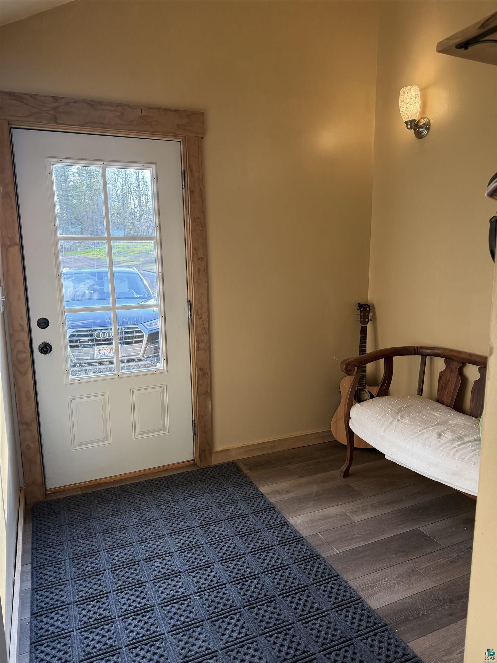 5274 Marble Lake Road Two Harbors, MN 55616 - Photo 49 of 79 Entryway featuring a glass-paneled door with natural wood trim, wood-finish flooring, and a wall-mounted sconce