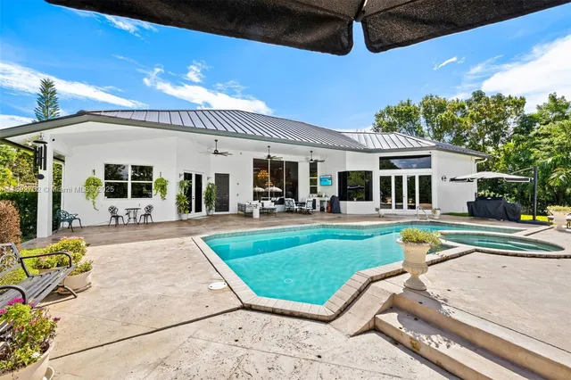 a swimming pool view with a seating space and a garden view