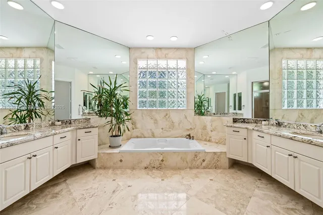 a bathroom with a granite countertop sink a large mirror and a shower