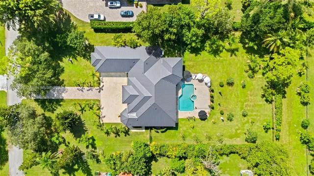 an aerial view of a house with swimming pool and garden