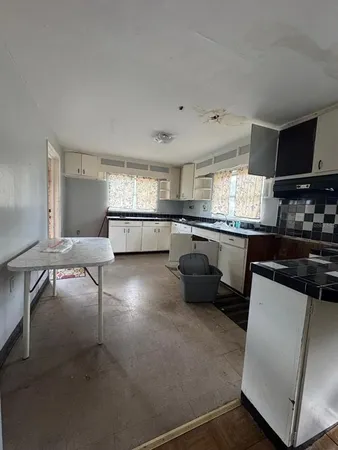a kitchen with a sink cabinets and wooden floor