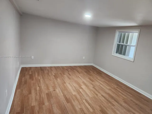 a view of an empty room and wooden floor