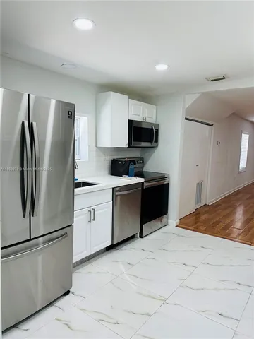 a kitchen with granite countertop a refrigerator and a stove