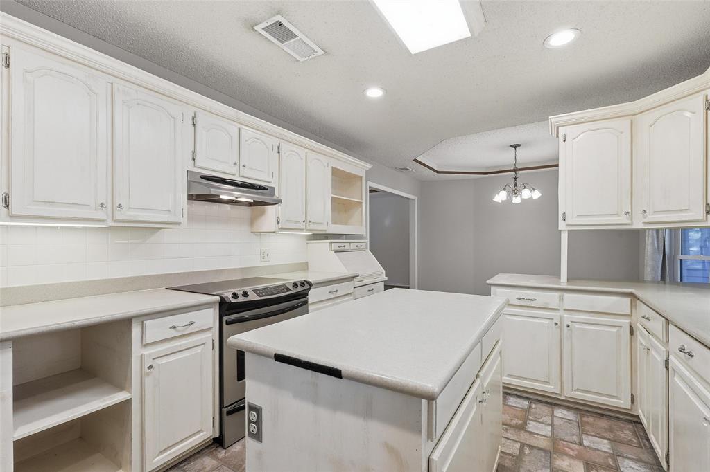 6140 Dick Price Road Fort Worth, TX 76140 - Photo 11 of 40 a kitchen with white cabinets and white appliances