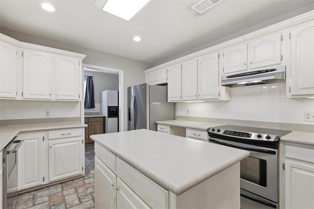 6140 Dick Price Road Fort Worth, TX 76140 - Photo 12 of 40 a kitchen with white cabinets and appliances