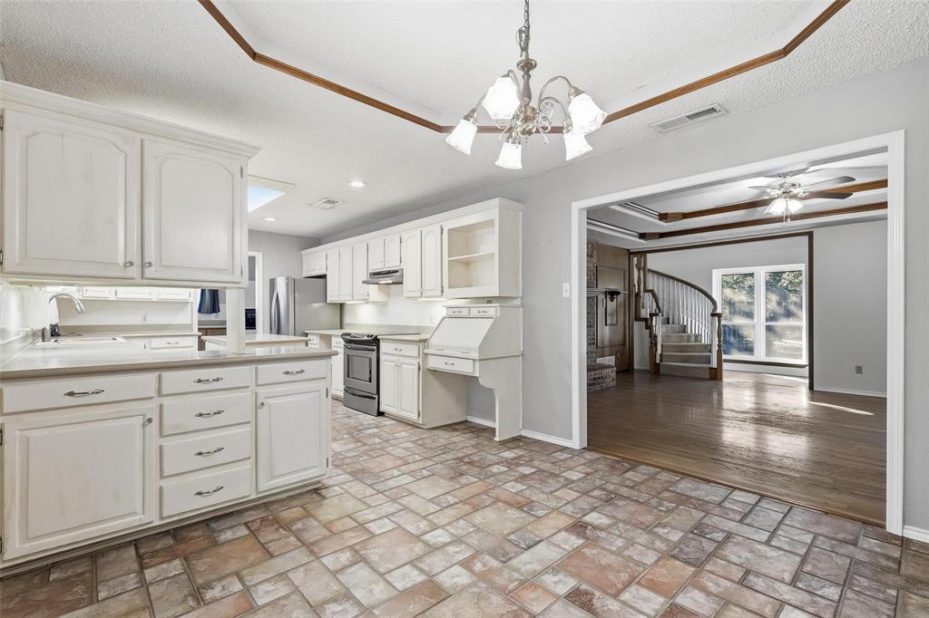 6140 Dick Price Road Fort Worth, TX 76140 - Photo 14 of 40 a open kitchen with a sink dishwasher a stove and white cabinets with wooden floor