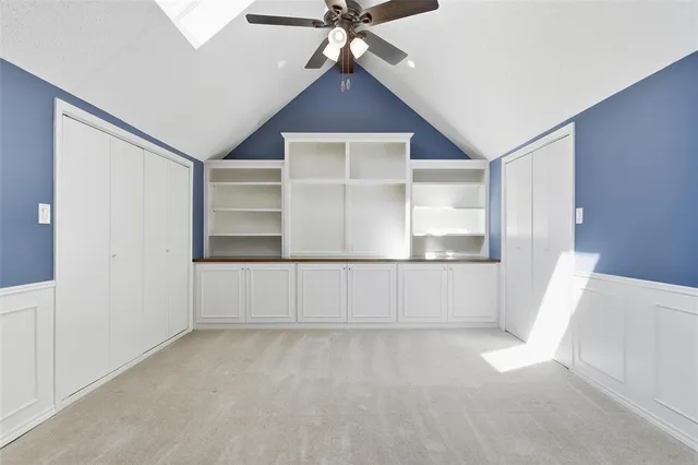 a view of an empty room with cabinet and a window