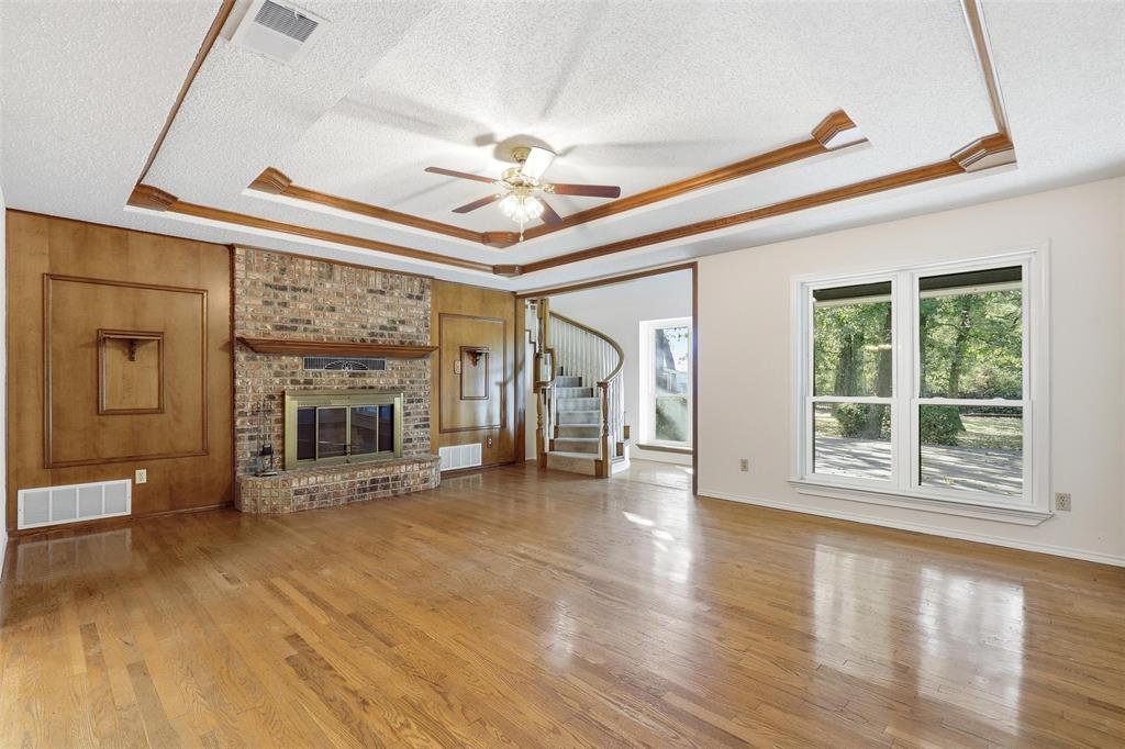 6140 Dick Price Road Fort Worth, TX 76140 - Photo 8 of 40 a view of an empty room with wooden floor fireplace and a window