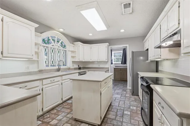 a kitchen with a sink stove and cabinets