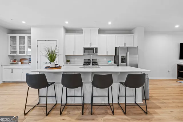 a kitchen with stainless steel appliances kitchen island granite countertop a stove a sink and a refrigerator