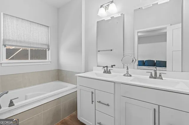 a bathroom with a tub a sink and mirror