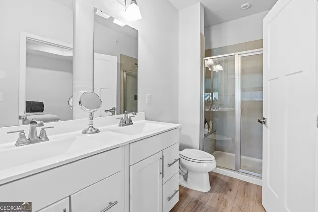 a bathroom with a double vanity sink toilet and shower