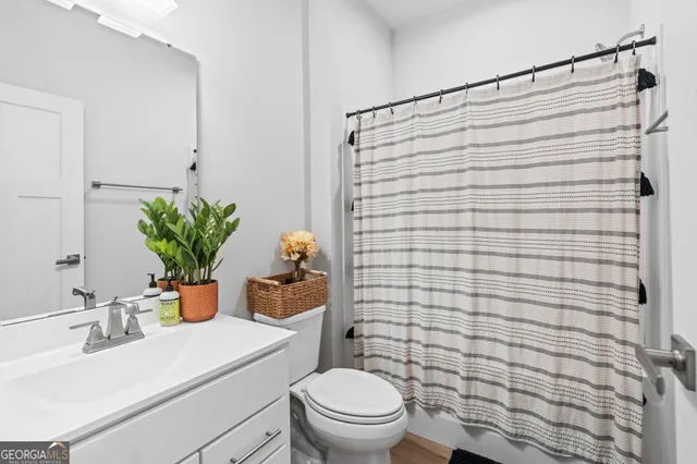 a bathroom with a sink a toilet and shower curtain